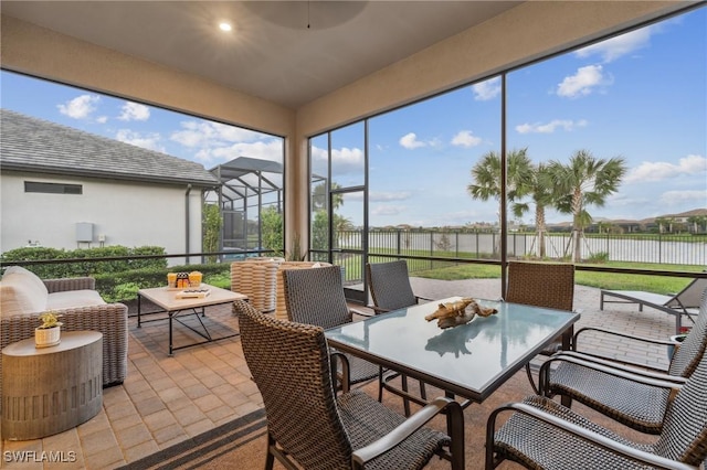 sunroom / solarium featuring a water view