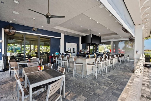 view of patio featuring outdoor dry bar and ceiling fan