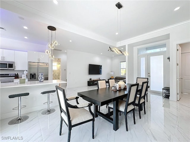 dining space with crown molding and french doors