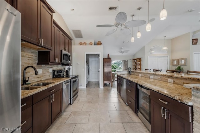 kitchen featuring appliances with stainless steel finishes, decorative light fixtures, beverage cooler, and sink