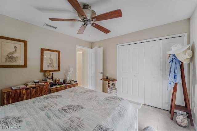 bedroom with light tile patterned floors, a closet, and ceiling fan