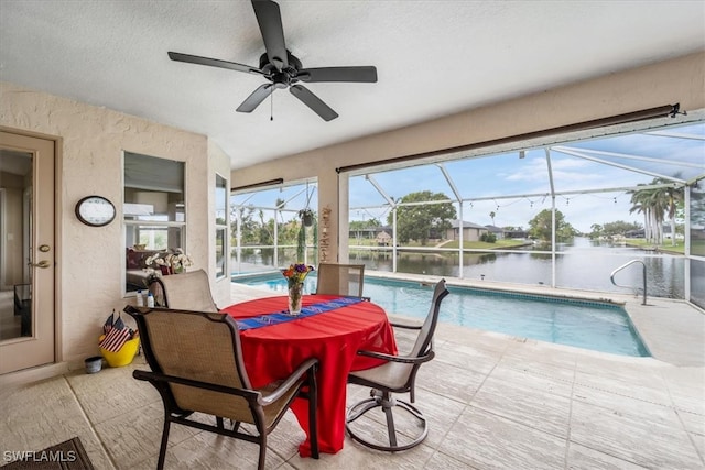 view of swimming pool featuring ceiling fan and a water view