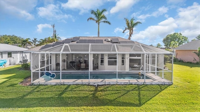 rear view of property with a lanai and a yard