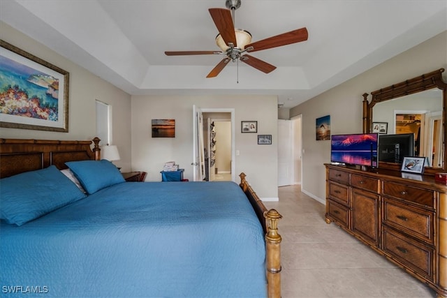 bedroom with a raised ceiling, ceiling fan, and light tile patterned floors