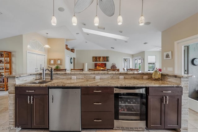 kitchen with dark brown cabinets, wine cooler, and lofted ceiling with skylight