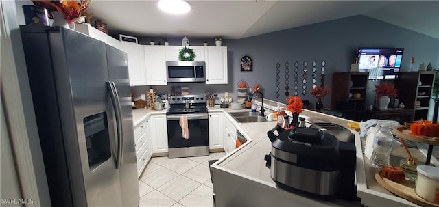 kitchen featuring white cabinetry, sink, vaulted ceiling, and stainless steel appliances