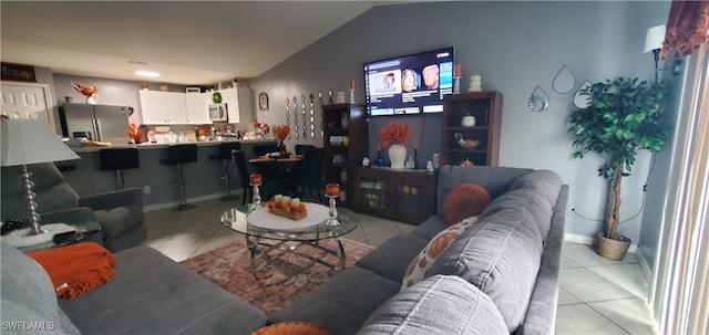 living room featuring vaulted ceiling and light tile patterned floors