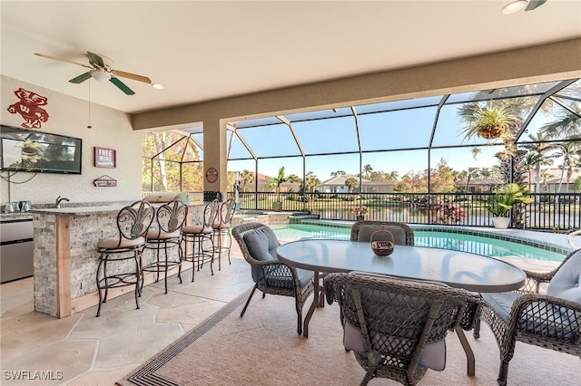 view of patio with glass enclosure, an outdoor bar, ceiling fan, and a fenced in pool