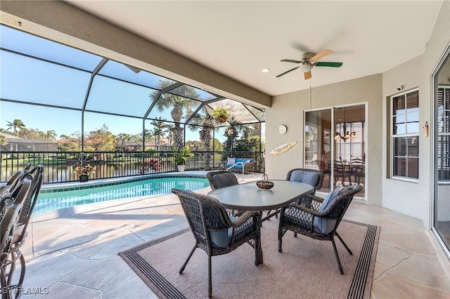 view of pool featuring glass enclosure, ceiling fan, and a patio