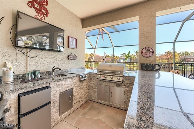 view of patio with sink, area for grilling, a lanai, and a grill