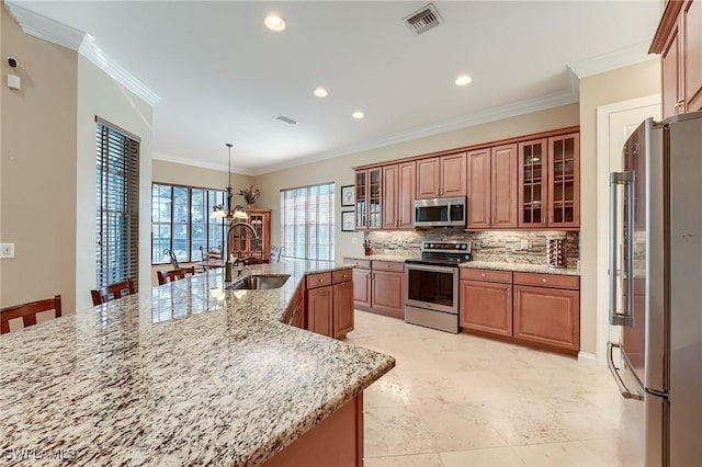 kitchen featuring a large island, sink, ornamental molding, and appliances with stainless steel finishes