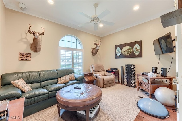 living room featuring crown molding, ceiling fan, and light colored carpet