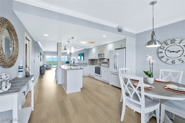 kitchen with sink, decorative light fixtures, decorative backsplash, and appliances with stainless steel finishes