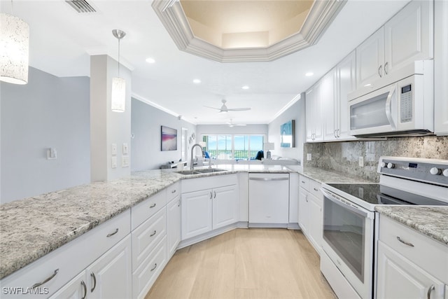 kitchen with pendant lighting, sink, white appliances, white cabinetry, and decorative backsplash