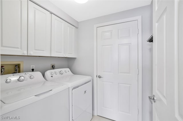 washroom featuring cabinets and independent washer and dryer