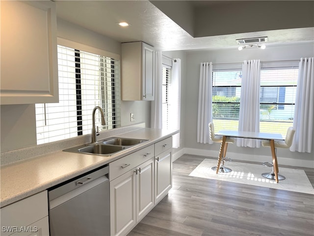 kitchen featuring dishwasher, sink, white cabinets, and light hardwood / wood-style floors