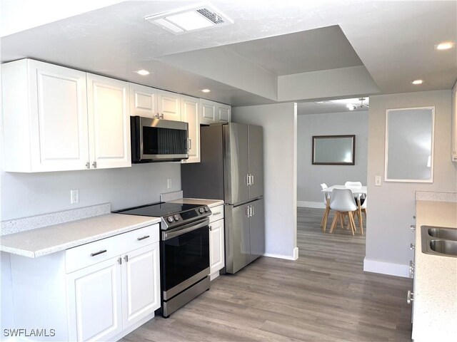 kitchen featuring white cabinets, sink, stainless steel appliances, and light hardwood / wood-style flooring