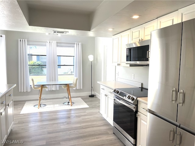 kitchen featuring white cabinets, light wood-type flooring, and stainless steel appliances