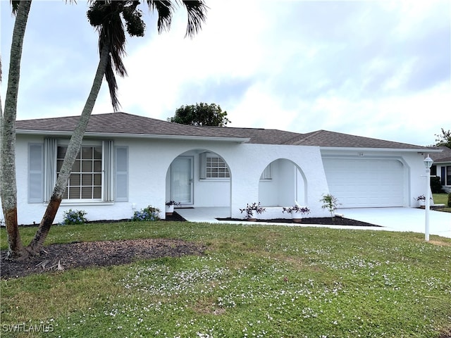 ranch-style house featuring a garage and a front lawn