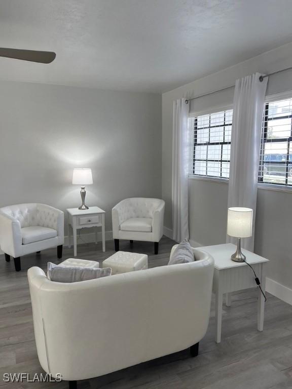 living room featuring hardwood / wood-style flooring, ceiling fan, and a healthy amount of sunlight