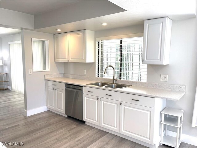 kitchen with dishwasher, light hardwood / wood-style floors, white cabinetry, and sink