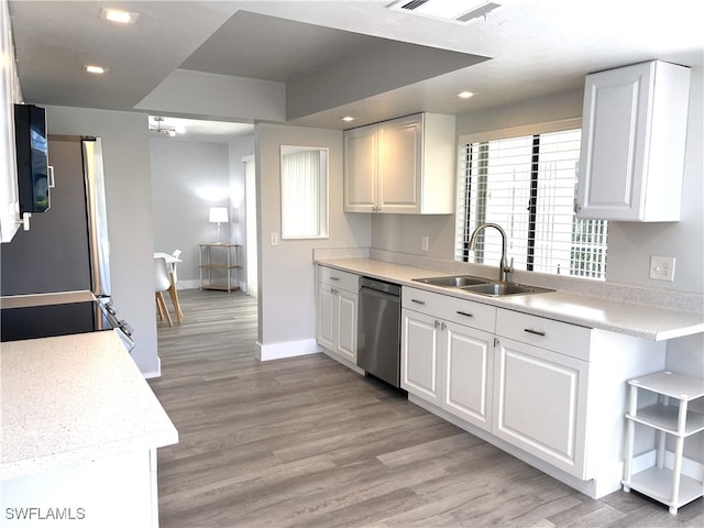 kitchen with dishwasher, white cabinetry, and sink