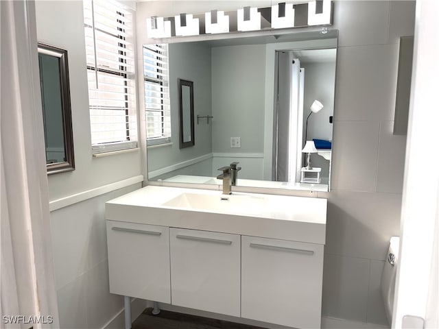 bathroom featuring vanity and tile walls