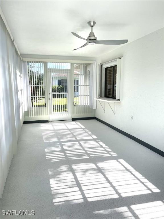 unfurnished sunroom with ceiling fan