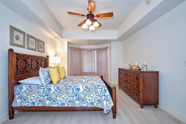 bedroom featuring wood finished floors, baseboards, and a ceiling fan