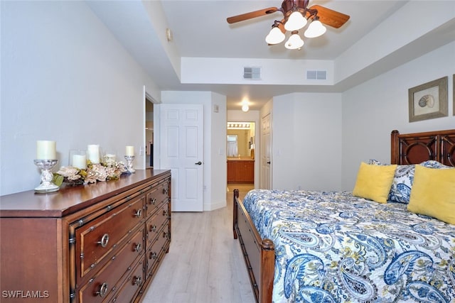 bedroom with ensuite bathroom, ceiling fan, and light wood-type flooring