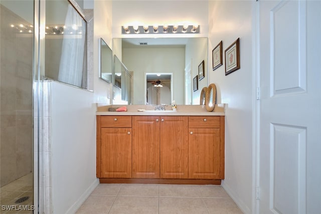 bathroom featuring a stall shower, tile patterned flooring, a ceiling fan, baseboards, and vanity
