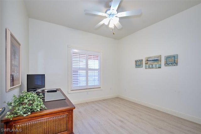 unfurnished office featuring wood finished floors, a ceiling fan, and baseboards