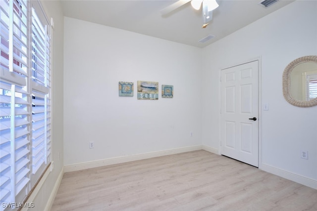 spare room featuring light wood-style floors, ceiling fan, and baseboards