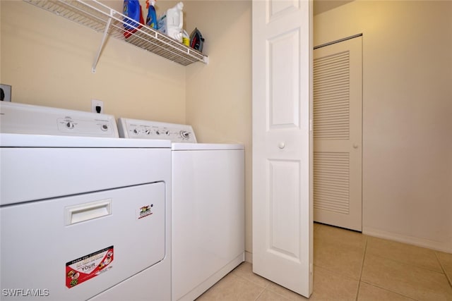 clothes washing area with washing machine and clothes dryer and light tile patterned floors