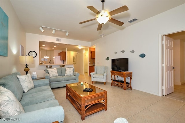 living area featuring a ceiling fan, light tile patterned flooring, baseboards, and track lighting