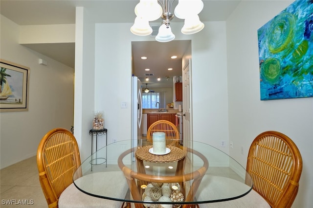 dining area featuring sink, a notable chandelier, and light tile patterned floors