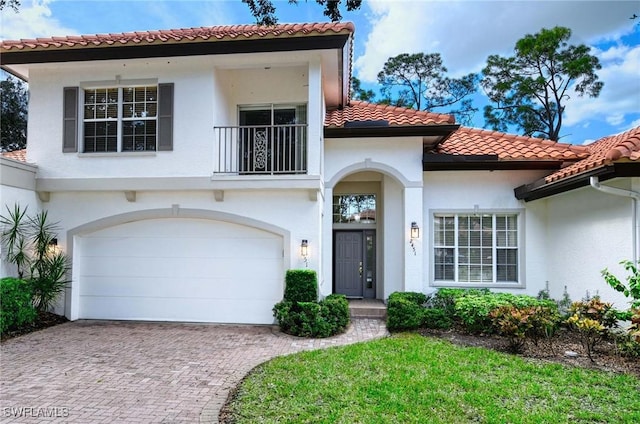 2451 Game Hawk Ct Unit 2502, Naples, FL 34105 - mediterranean / spanish-style home featuring a balcony, decorative driveway, a garage, a tiled roof, and stucco siding