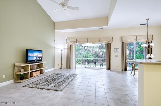 tiled living room with ceiling fan with notable chandelier