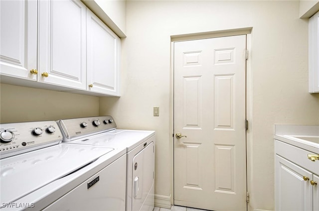 washroom with cabinets and washer and dryer