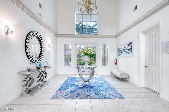 tiled foyer featuring a towering ceiling and an inviting chandelier