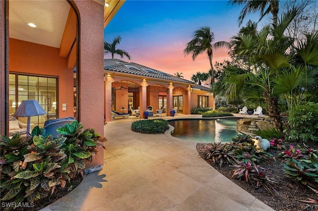 pool at dusk with a patio