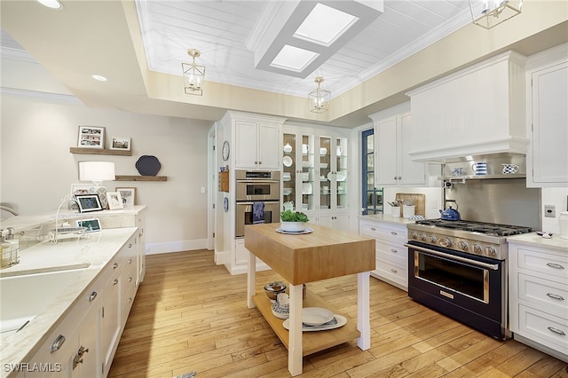 kitchen with white cabinetry, light wood-type flooring, and stainless steel appliances