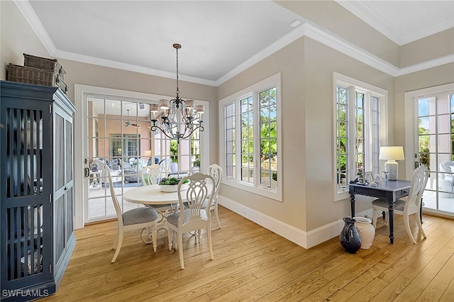 dining area featuring a chandelier, light hardwood / wood-style floors, and crown molding