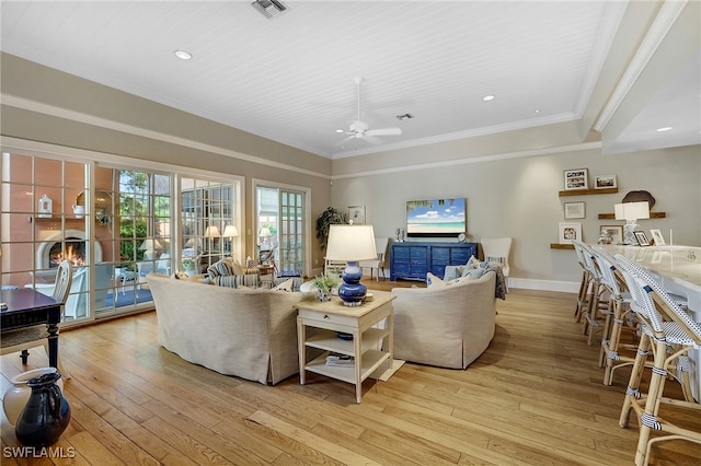 living room featuring ceiling fan, crown molding, and light wood-type flooring