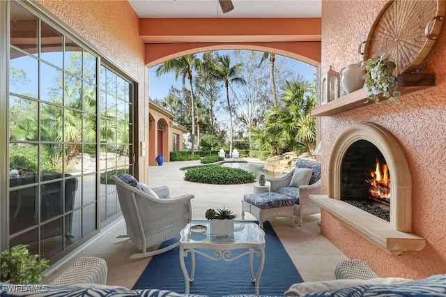 view of patio / terrace with ceiling fan and an outdoor fireplace