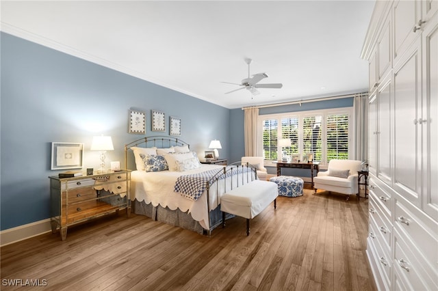 bedroom with hardwood / wood-style floors, ceiling fan, and crown molding