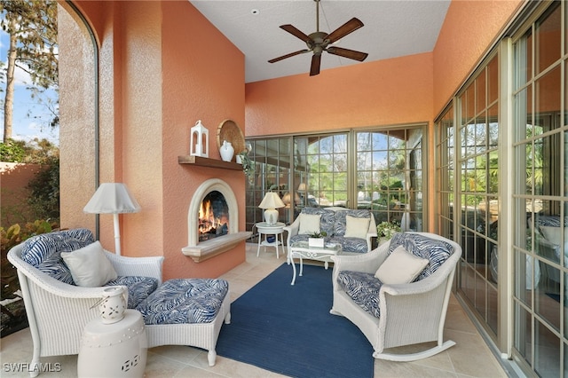 interior space featuring ceiling fan and an outdoor living space with a fireplace