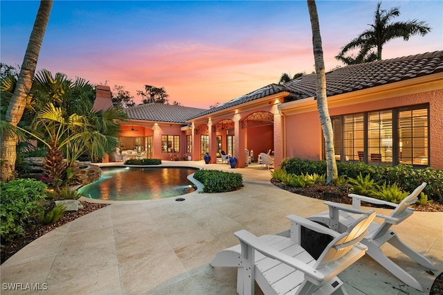 pool at dusk with a patio