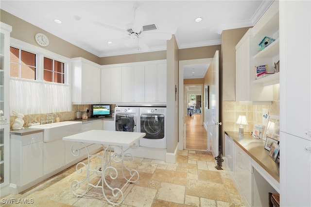 washroom featuring ornamental molding, sink, a healthy amount of sunlight, and washing machine and clothes dryer