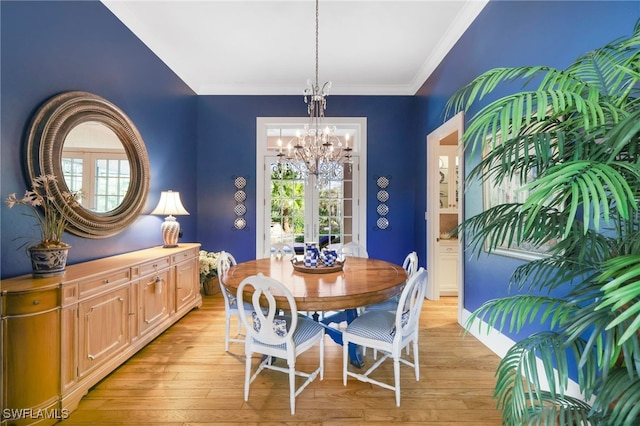 dining area featuring light hardwood / wood-style floors, an inviting chandelier, and crown molding